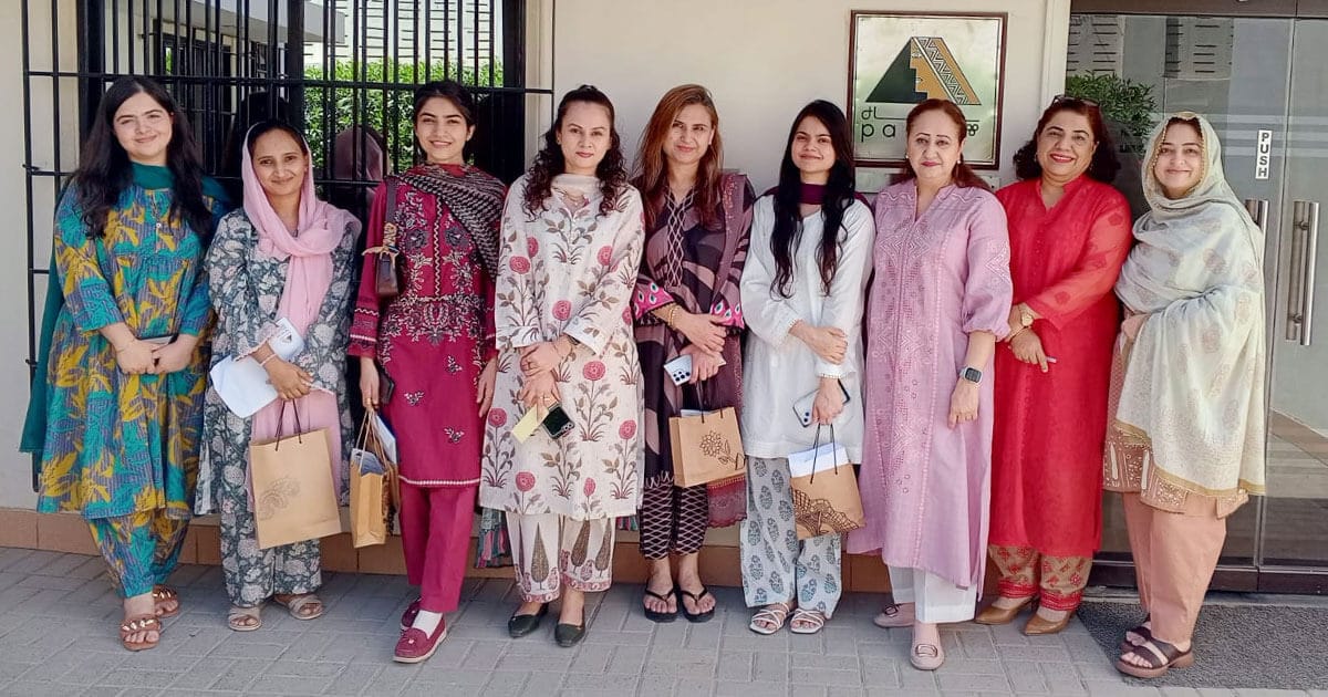 Women standing together during an AGI CARES community initiative focused on dignity and support.